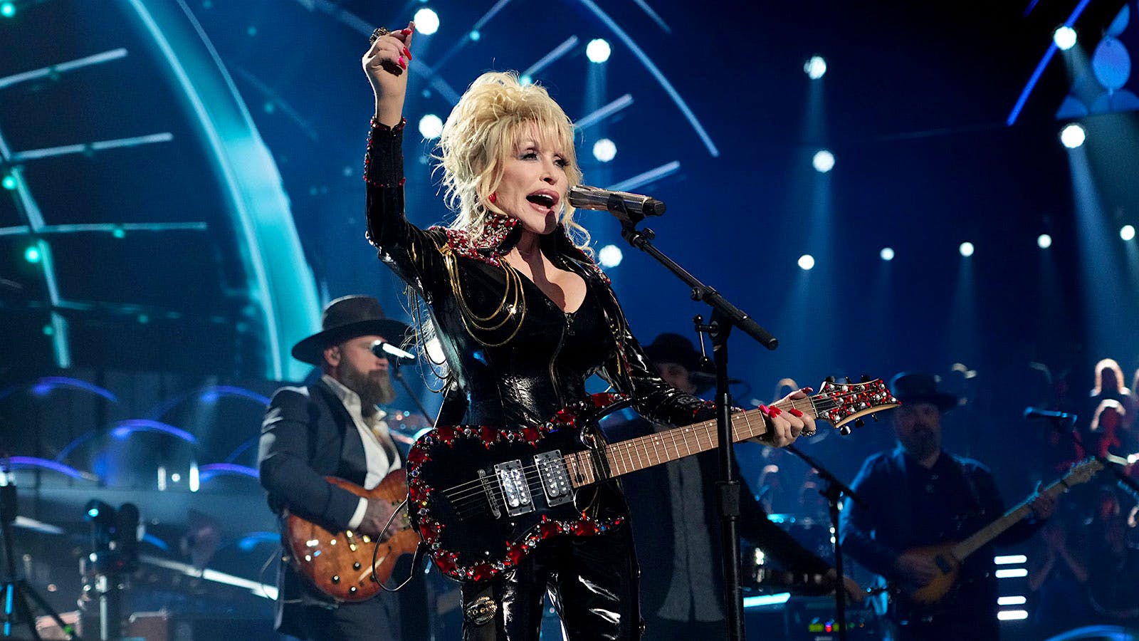 Country musician Dolly Parton performing onstage with a guitar