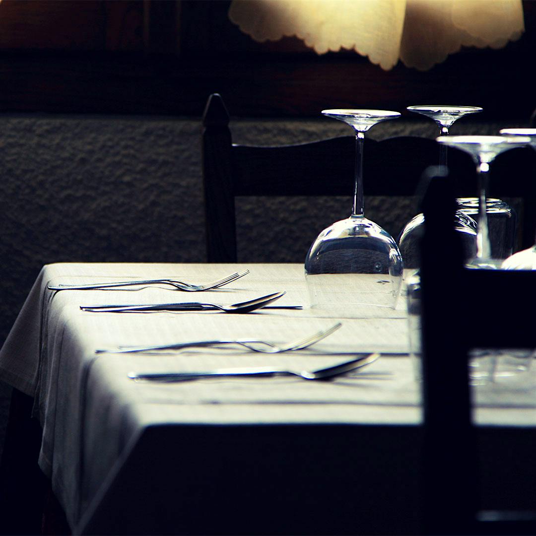 Empty wineglasses rest upside down on a table.
