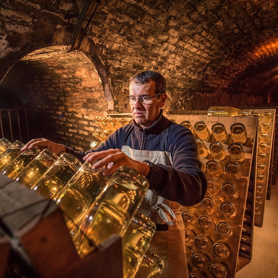 After Champagne undergoes a second fermentation in bottle to create the bubbles, sediment remains in the wine; "riddling" the bottles gradually moves the sediment into the neck where it can be more easily removed.