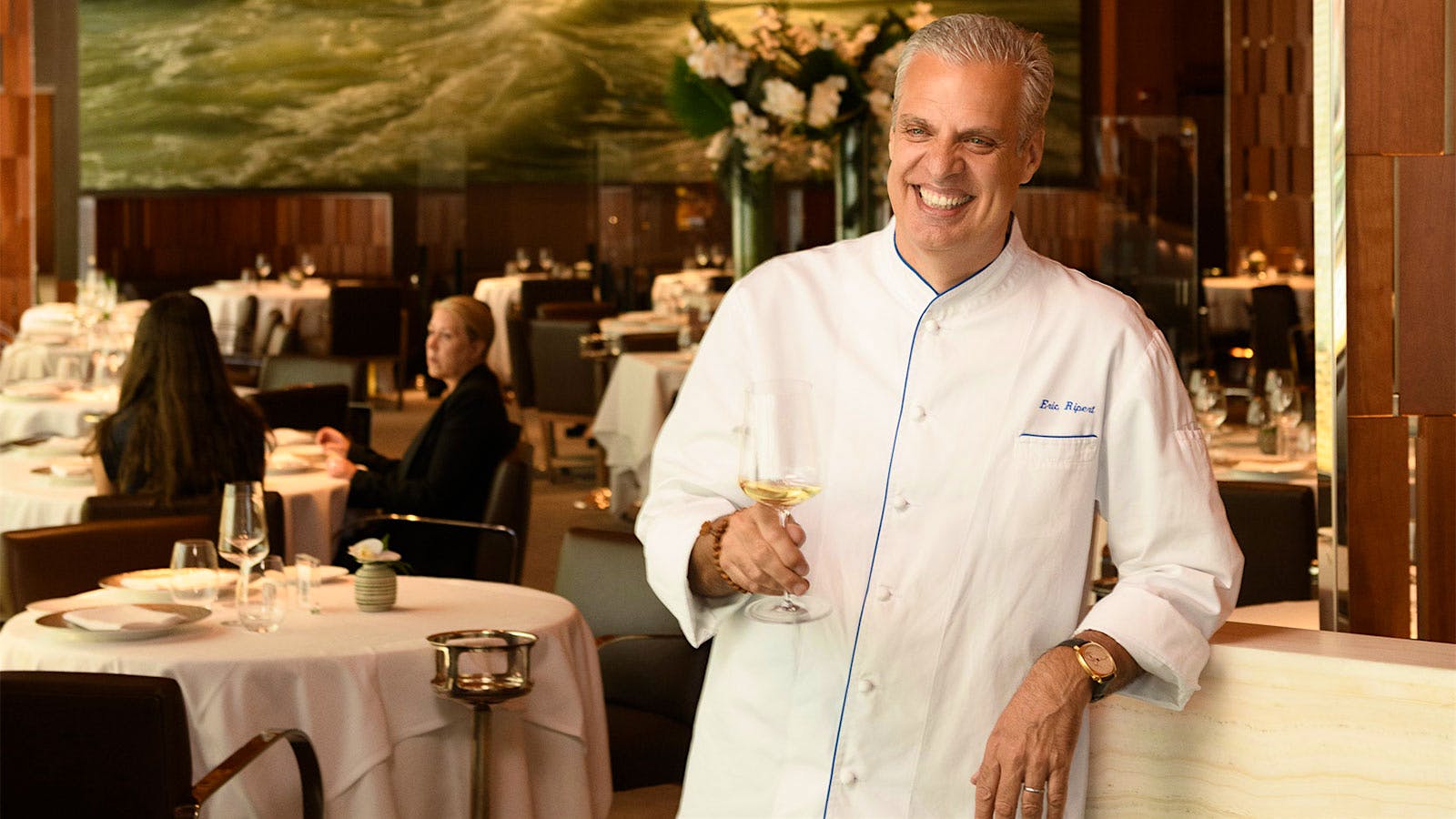  Eric Ripert drinking a glass of white wine in the dining room of Le Bernardin