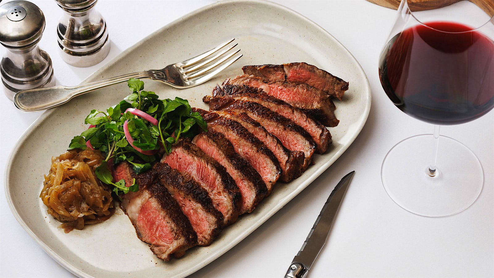  A steak next to a glass of red wine from Grill 23 in Boston