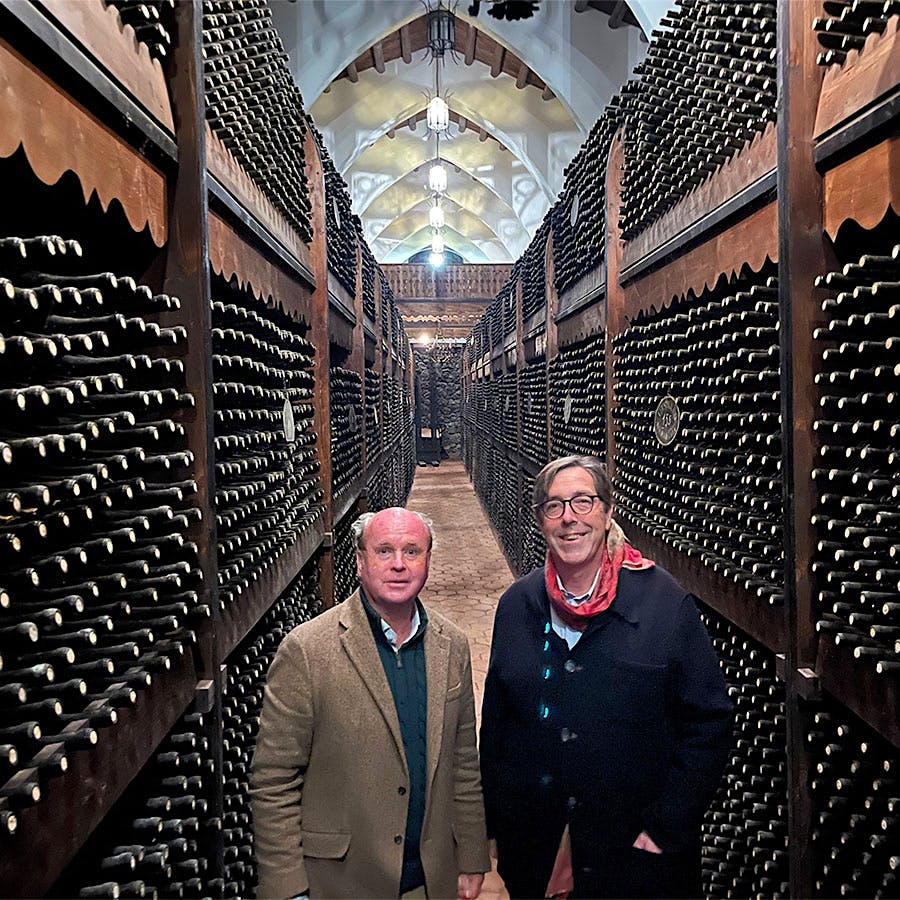  Baron Arnaldo Spitaleri and Planeta CEO Alessio Planeta stand amid tall, old, dark wooden racks of Castello Solicchiata&rsquo;s wine bottles under a cathedral-like arched ceiling