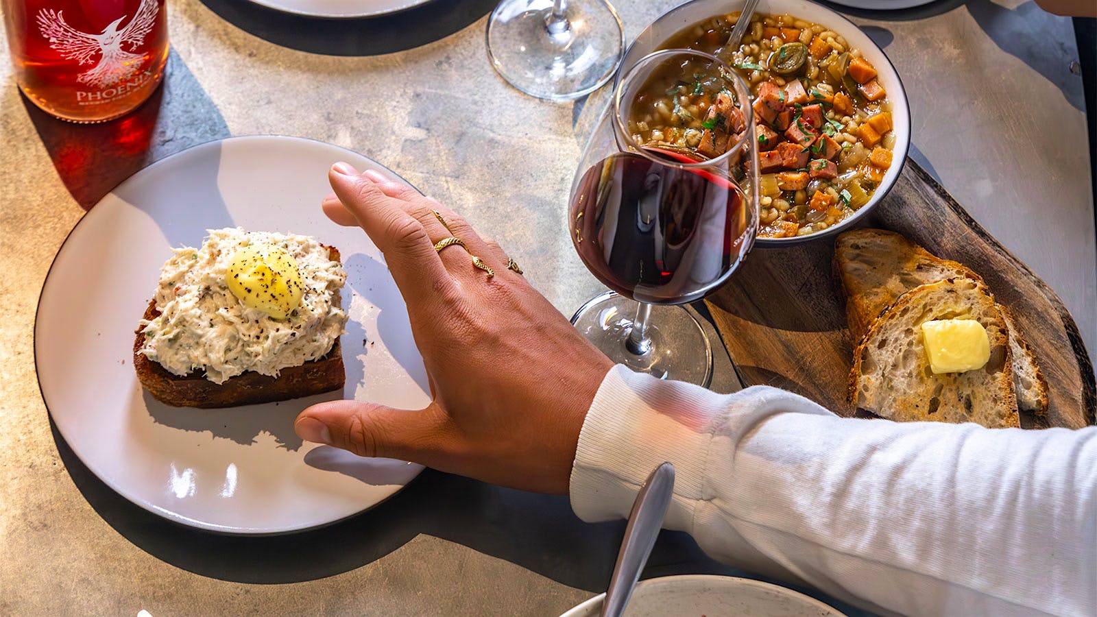  People enjoying wine and food at a table at 64 Wine