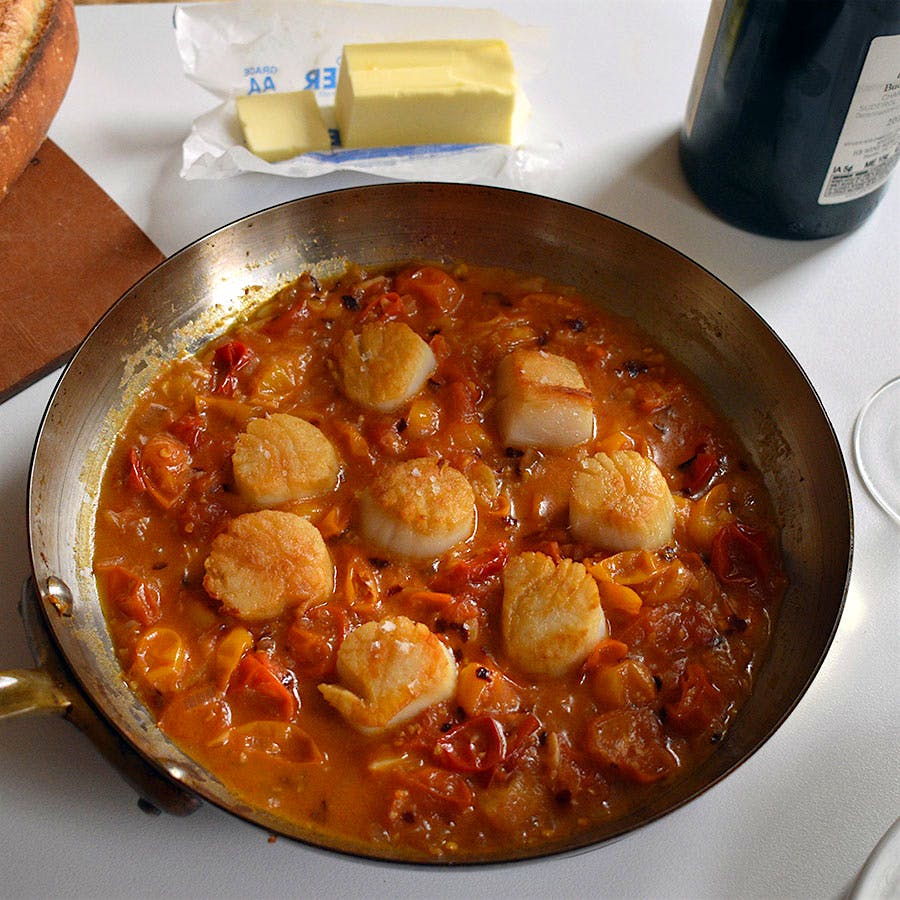 Cherry tomatoes, butter and a splash of white wine make a simple but decadent sauce to go with sea scallops.