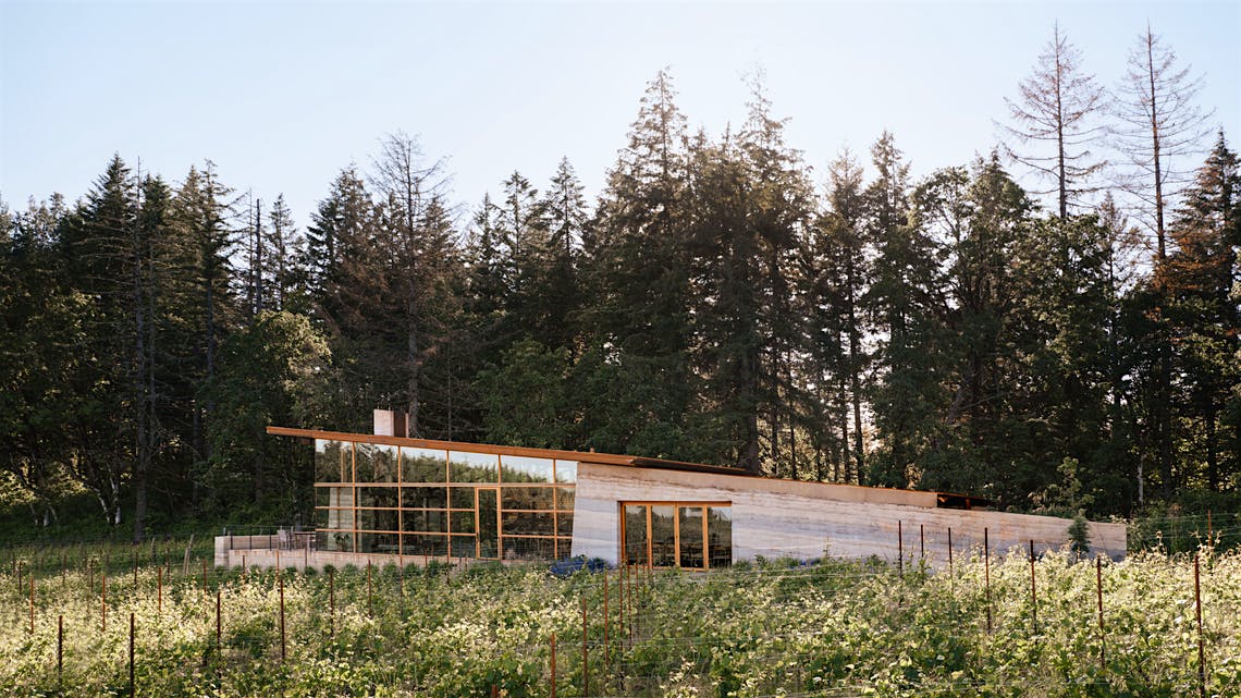  The exterior of Rodeo HIlls tasting room set along the Pear Vineyard with a backdrop of trees