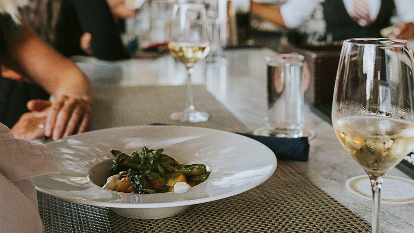  A vegetable dish and glasses of white wine from&nbsp;White Oak Kitchen &amp; Cocktails 