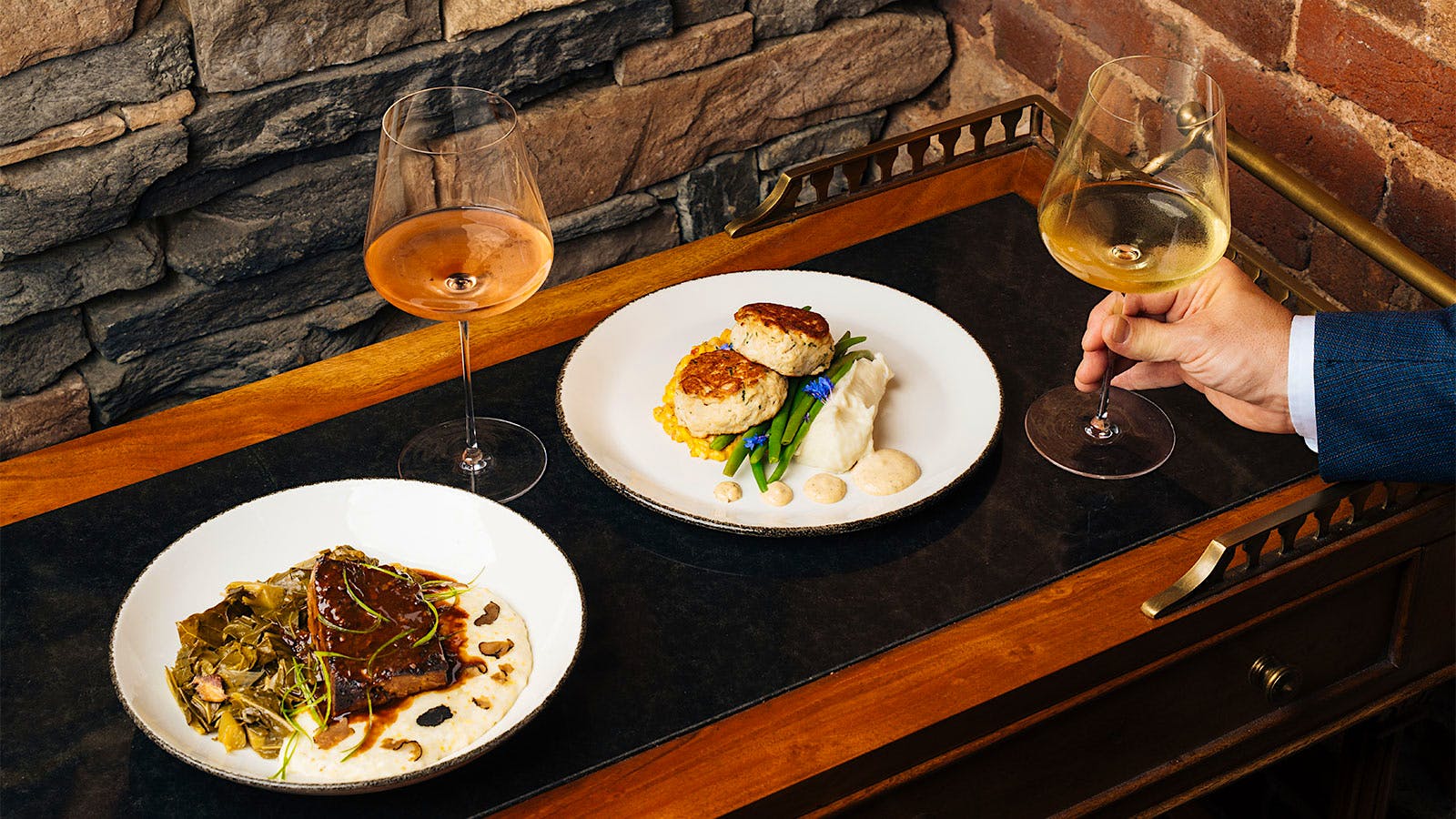  Braised beef short rib with truffled grits and crab cakes with sweet corn maque choux, accompanied by glasses of ros&eacute; and white wine