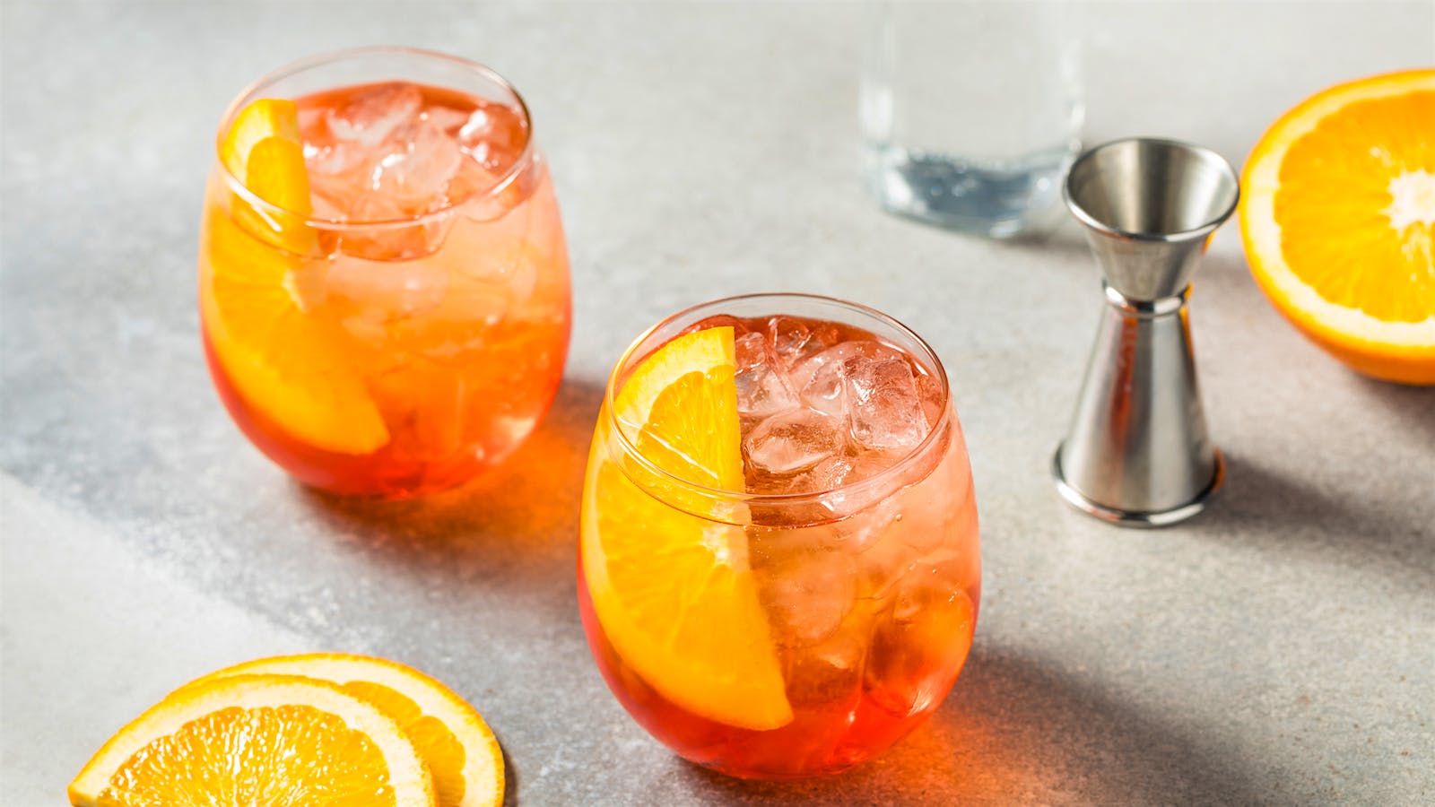  An Aperol spritz-style drink in a stemless wine glass garnished with orange slices