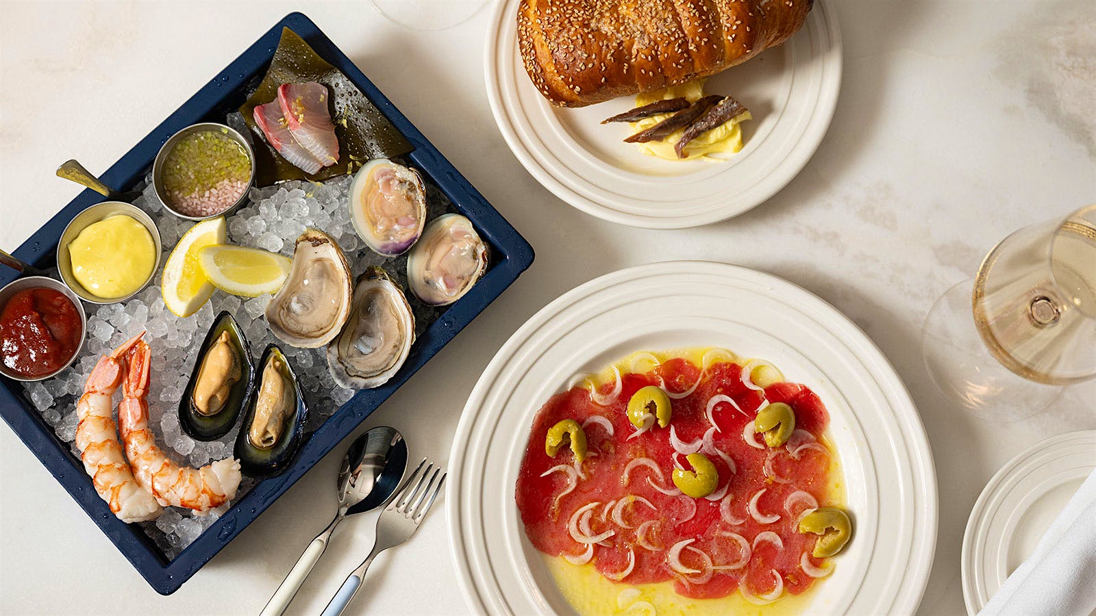  A selection of raw bar dishes and a glass of white wine from Penny