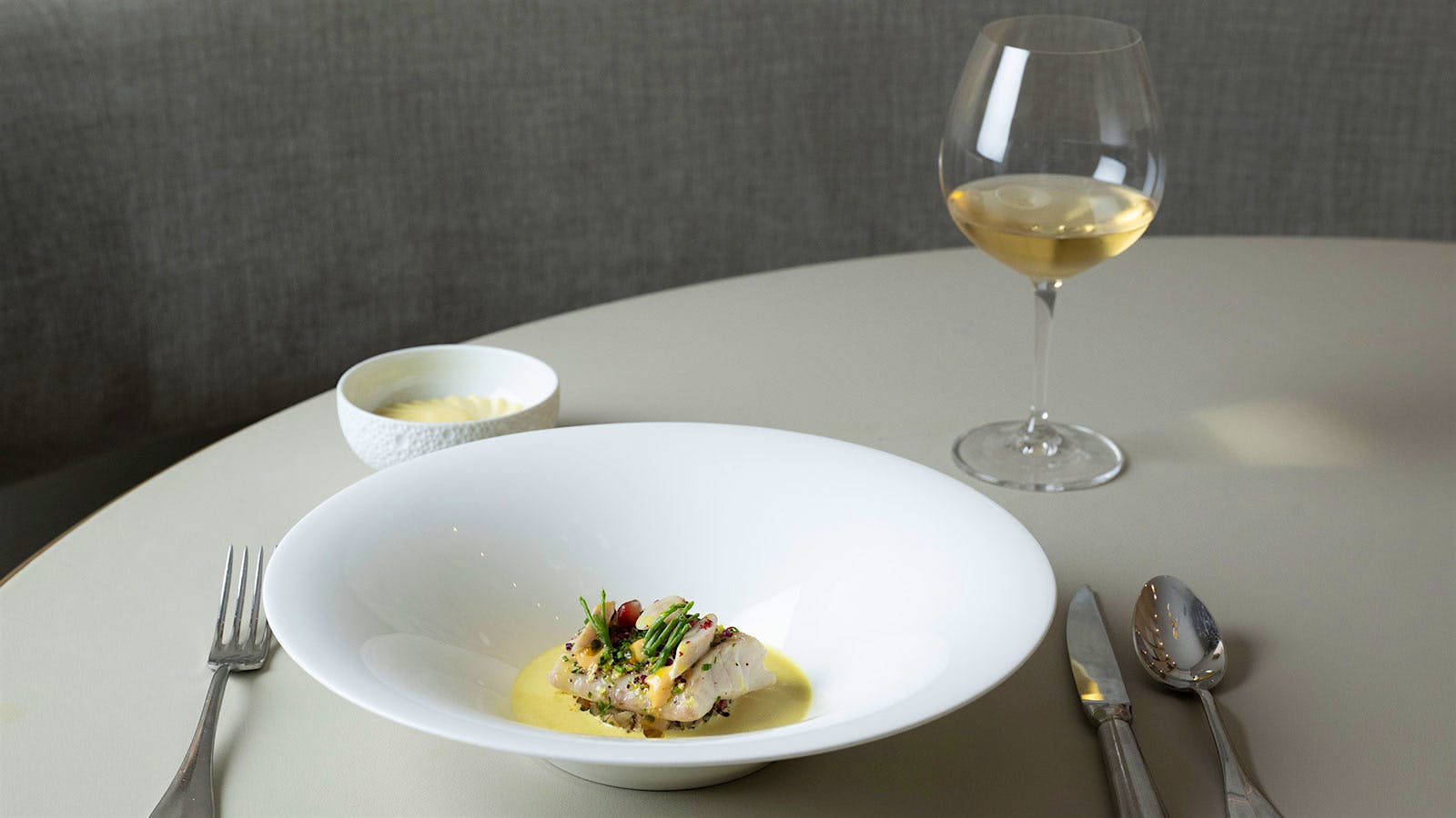  A white fish dish with a glass of wine from Essential by Christophe in New York City
