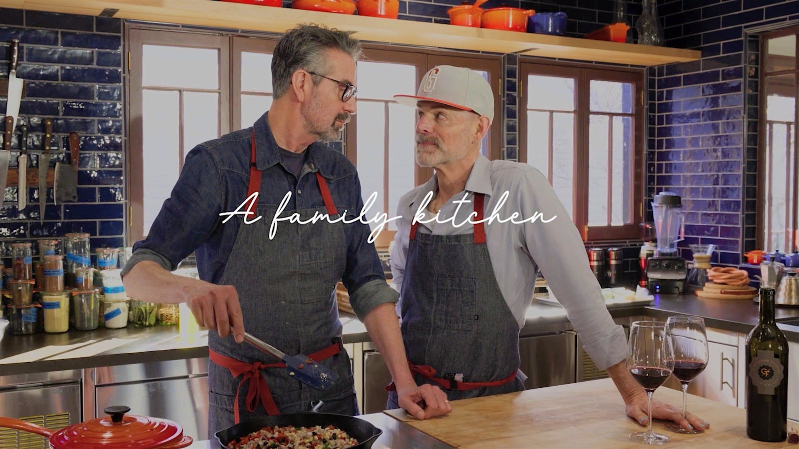  A still from &ldquo;Wine with Lunch on Mondays,&rdquo; showing vintners Joey Wolosz and Jeff Durham cooking, with text reading "a family kitchen."