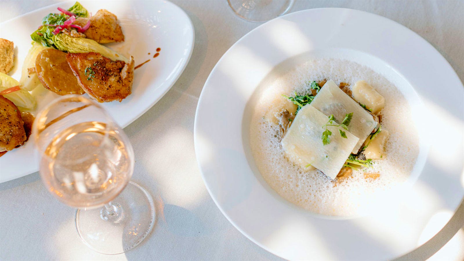 Dishes and glasses of wine from Auberge du Soleil in Napa Valley