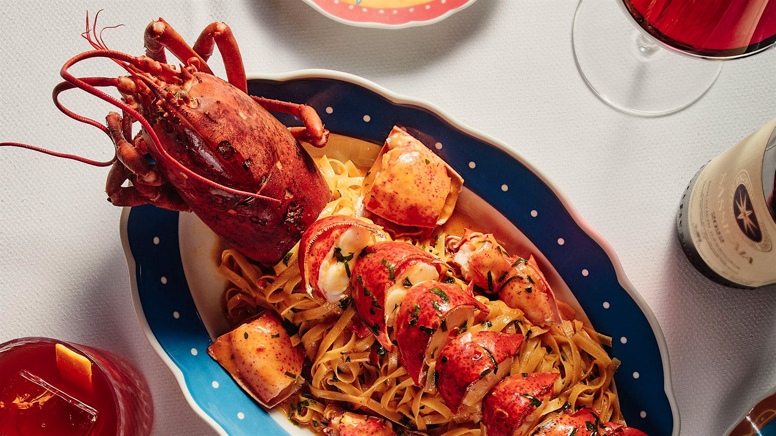  Lobster pasta dish from Carbone Riviera next to a bottle of wine