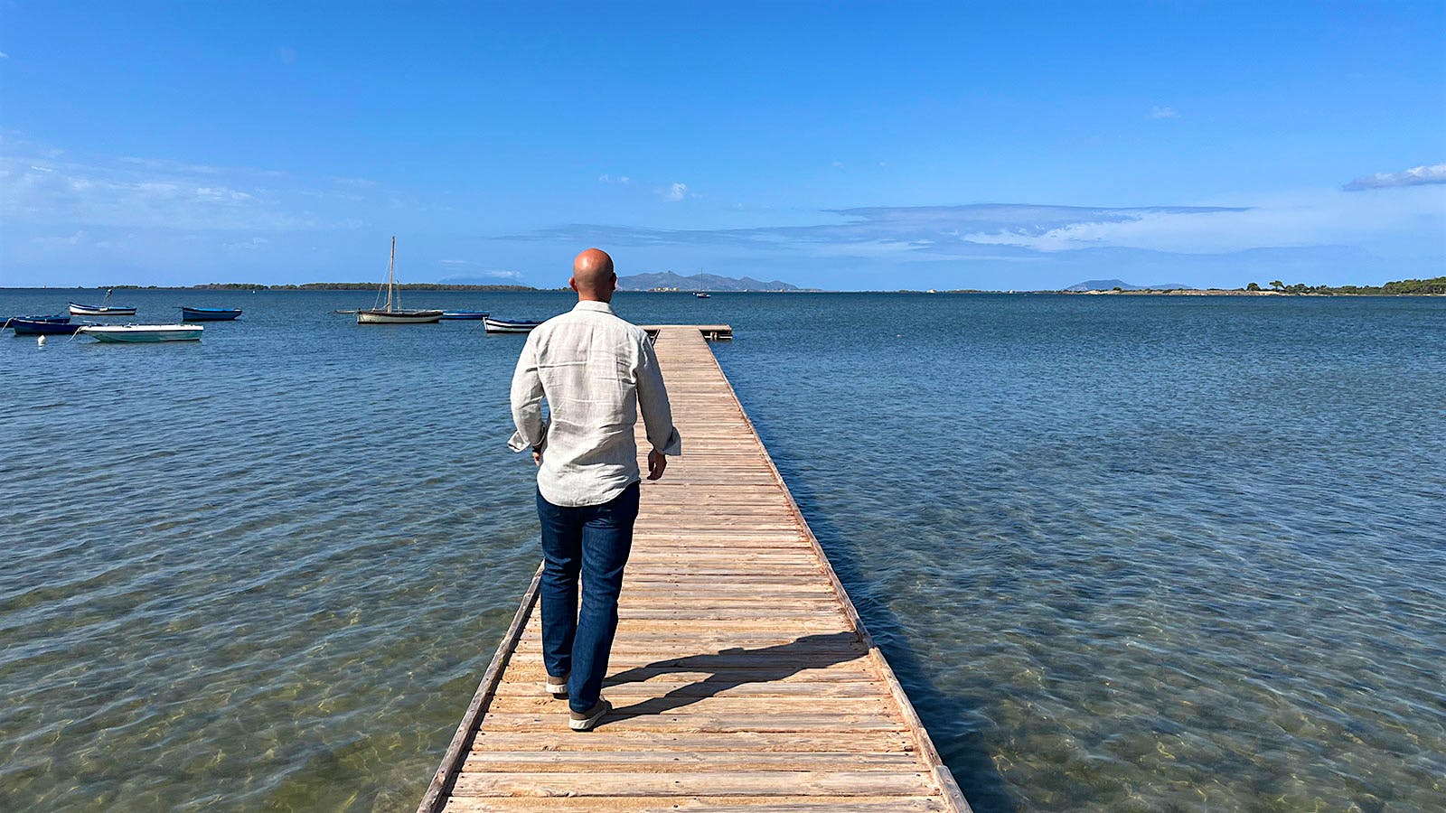  Pietro Russo stands on a wooden dock looking out across the waters of the Stagnone lagoon