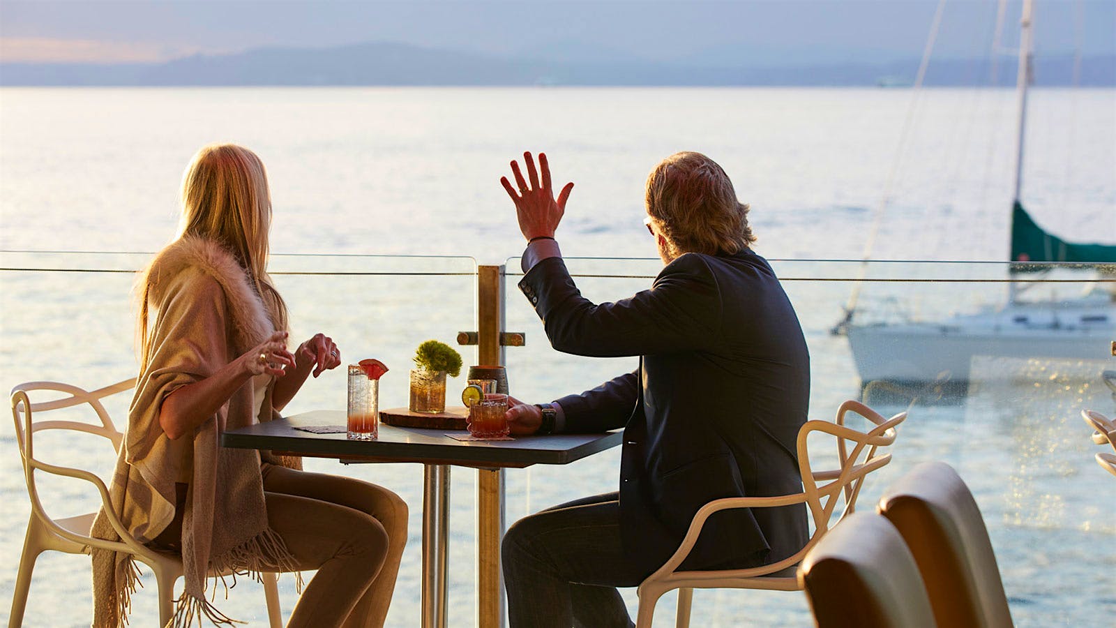  Guests waving to boats while dining at Six Seven Restaurant