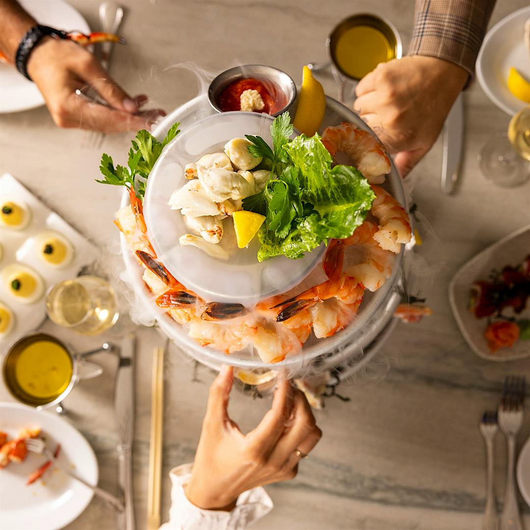 The “smoking” shellfish tower is a signature at Ocean Prime, where the menu blends seafood and modern steak house fare.
