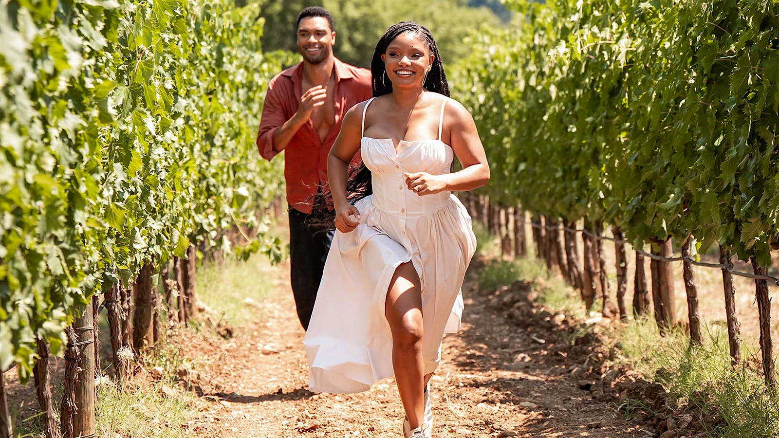 Reg&eacute;-Jean Page and Halle Balley running in a vineyard in "You, Me, and Tuscany&rdquo;&nbsp;from Universal Pictures.