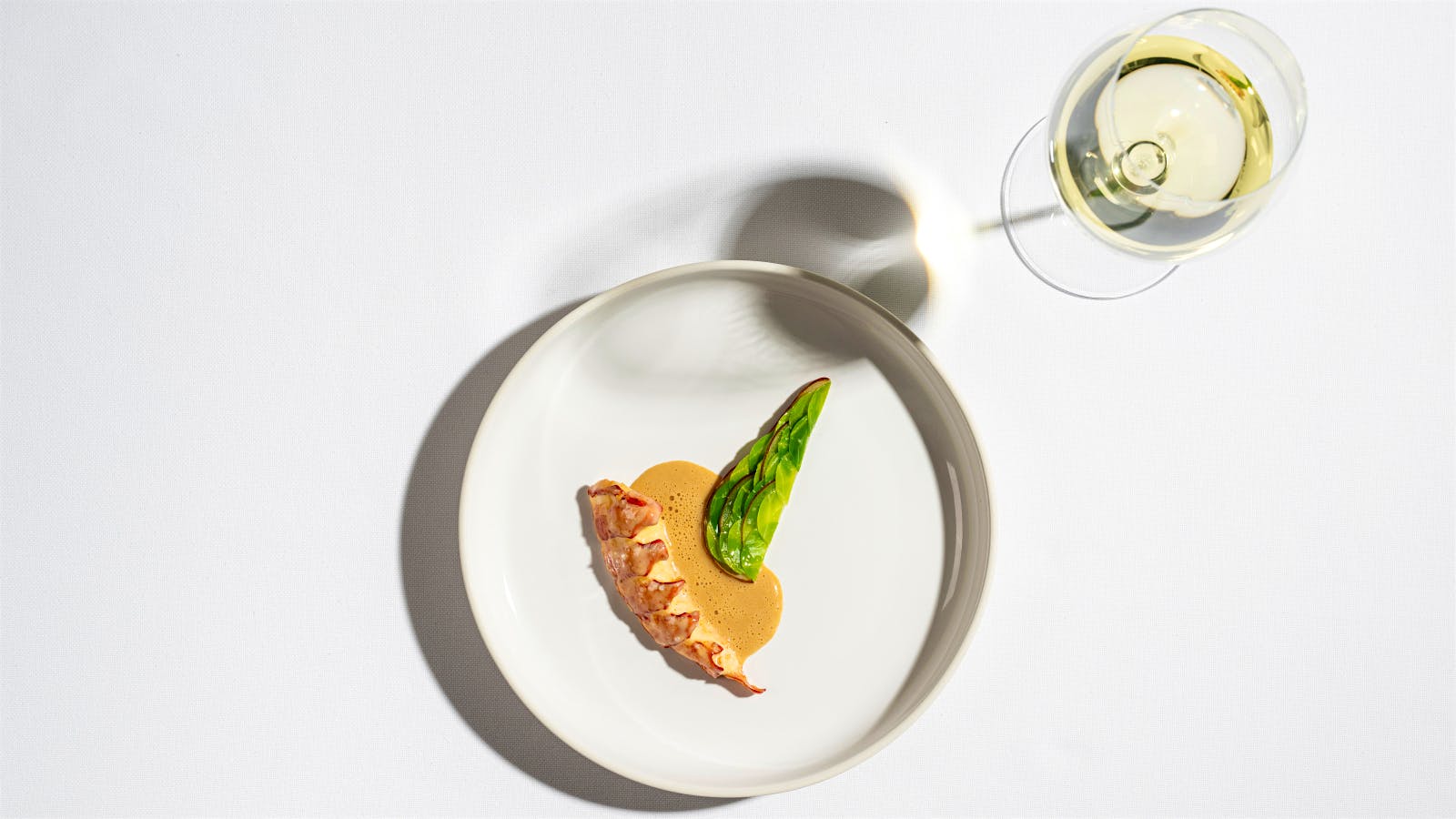 Lobster dish with a glass of white wine from Eleven Madison Park.