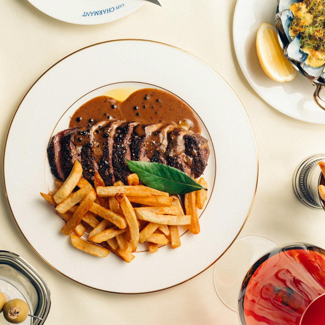 Cafe Charmant’s menu is heavy on seafood, but there are plenty of brasserie classics, including steak frites in peppercorn sauce.Catch Hospitality Group Tries a French Accent With Cafe Charmant