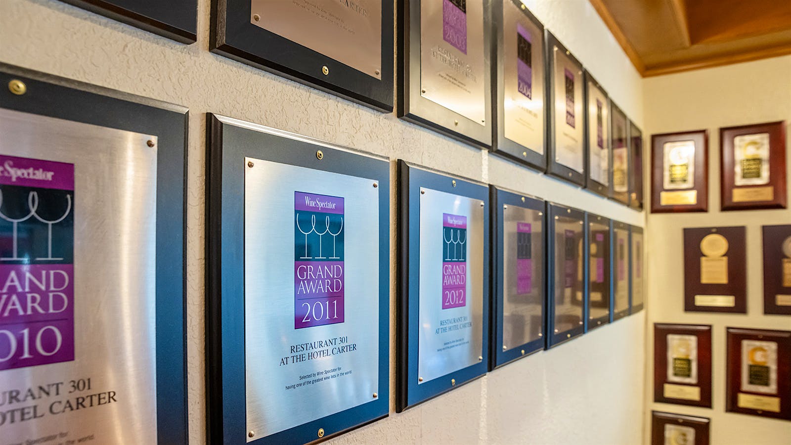  A wall featuring a collection of Wine Spectator Grand Award plaques won over the decades at Restaurant 301 in Eureka, California