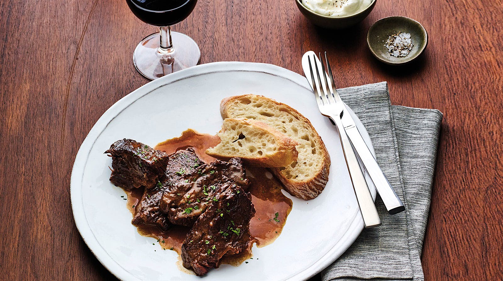 Chef William Bradley's braised short ribs plated with bread and horseradish cream on the side.