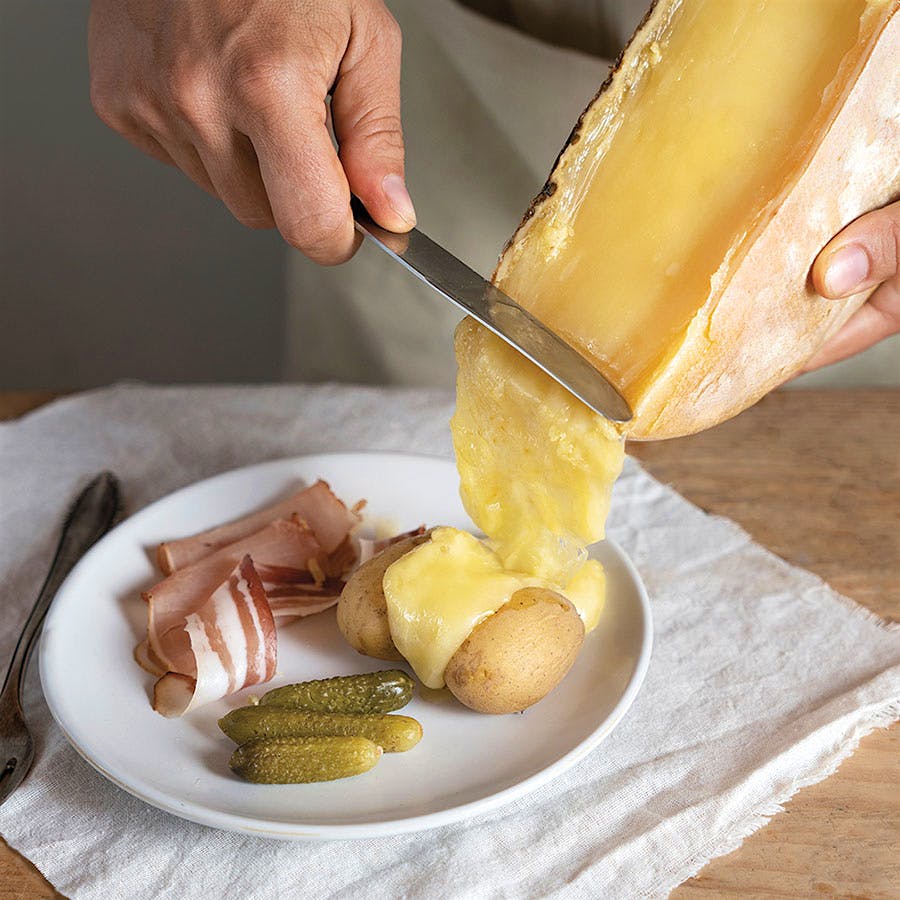Gooey raclette complements potatoes, meat, cornichons and beyond.