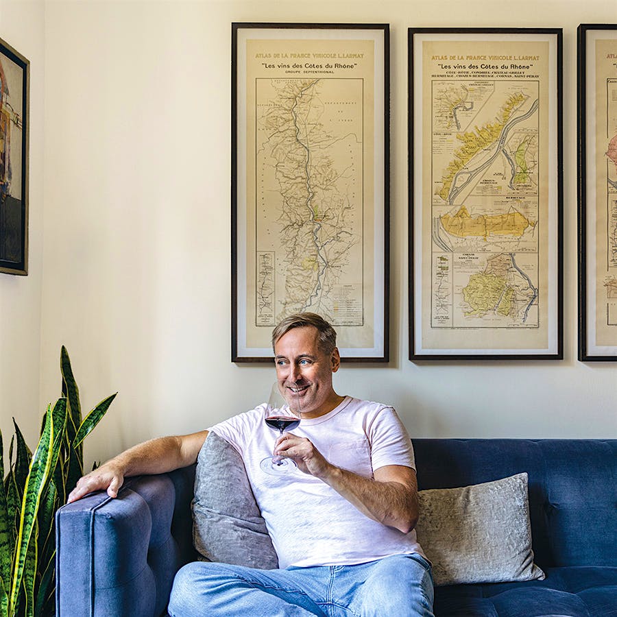 James Molesworth sips a glass of Pomerol in front of three Louis Larmat maps he's collected over the years.