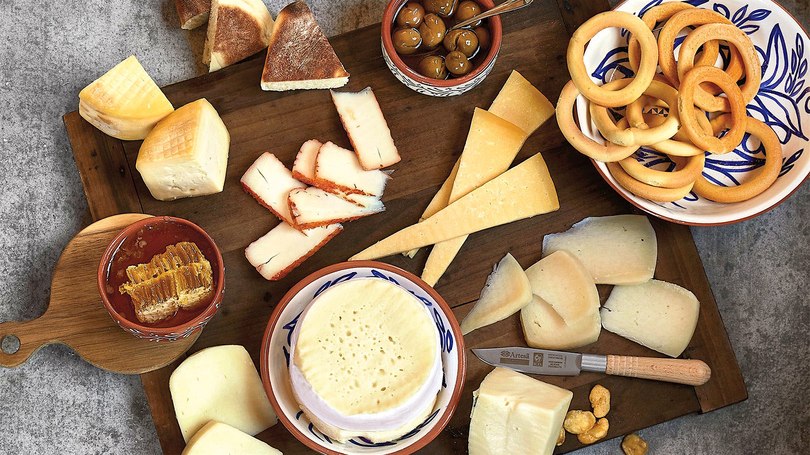 A cheese board with seven Portuguese cheeses of various textures