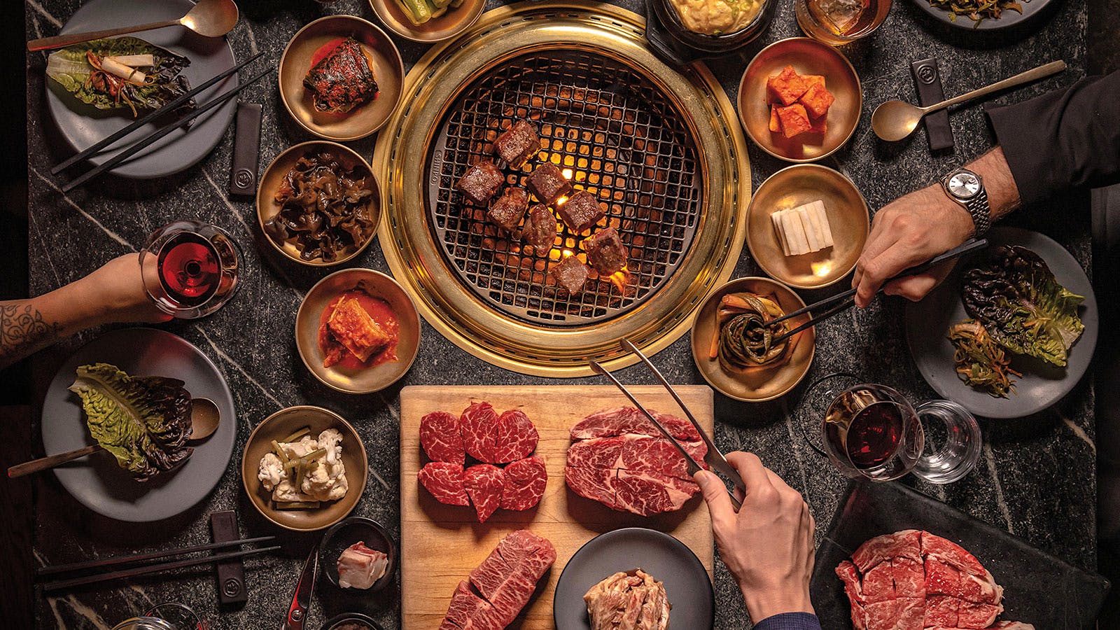 Overhead shot of the grills at Cote Miami, surrounded by cuts of beef and side dishes