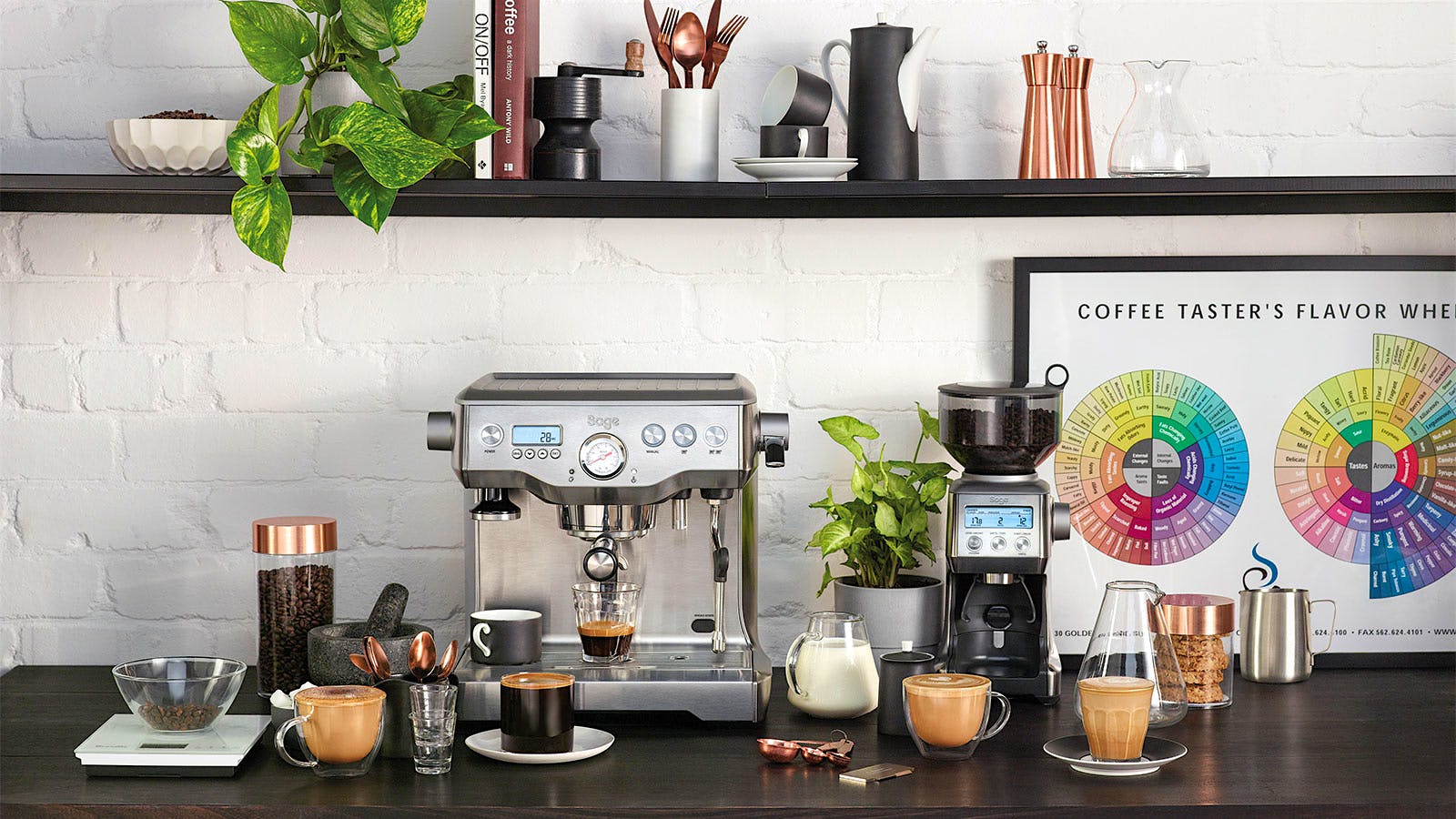 A Breville Dual Boiler espresso machine on a black countertop with multiple coffee gadgets and cups of coffee surrounding it