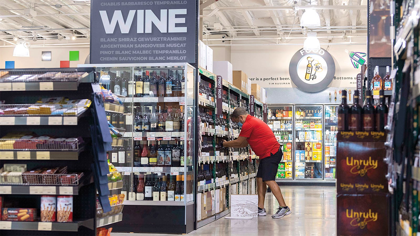 A staffer stocks wine shelves at an Irvine, California wine store.