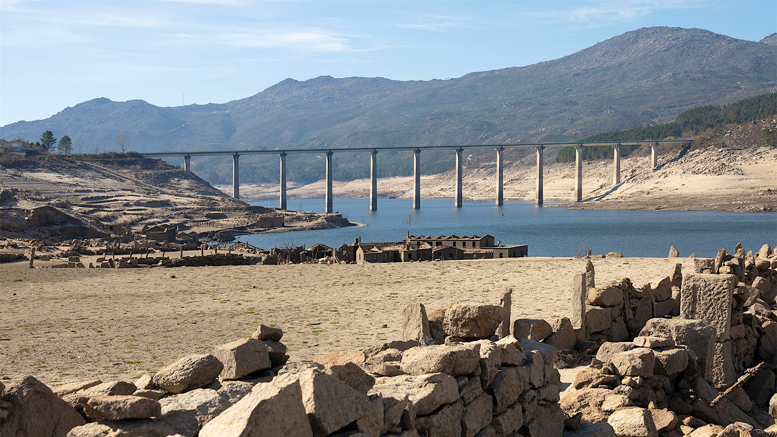 An aqueduct passes over a drained reservoir in Galicia, Spain.