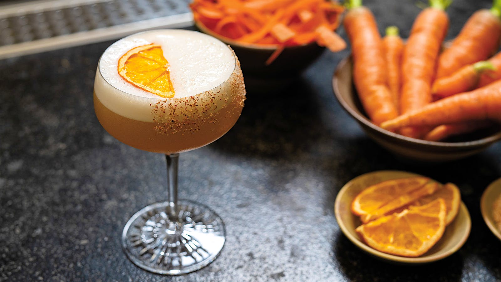 A carrot margarita from Little Saint alongside bowls of citrus and carrots
