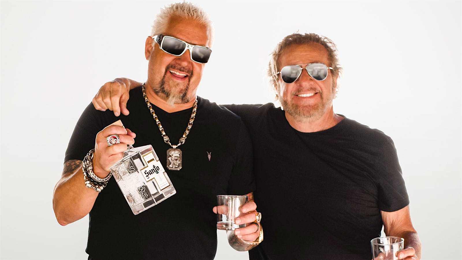 Guy Fieri (left) and Sammy Hagar and Guy Fieri stand together with a bottle of Santo Tequila