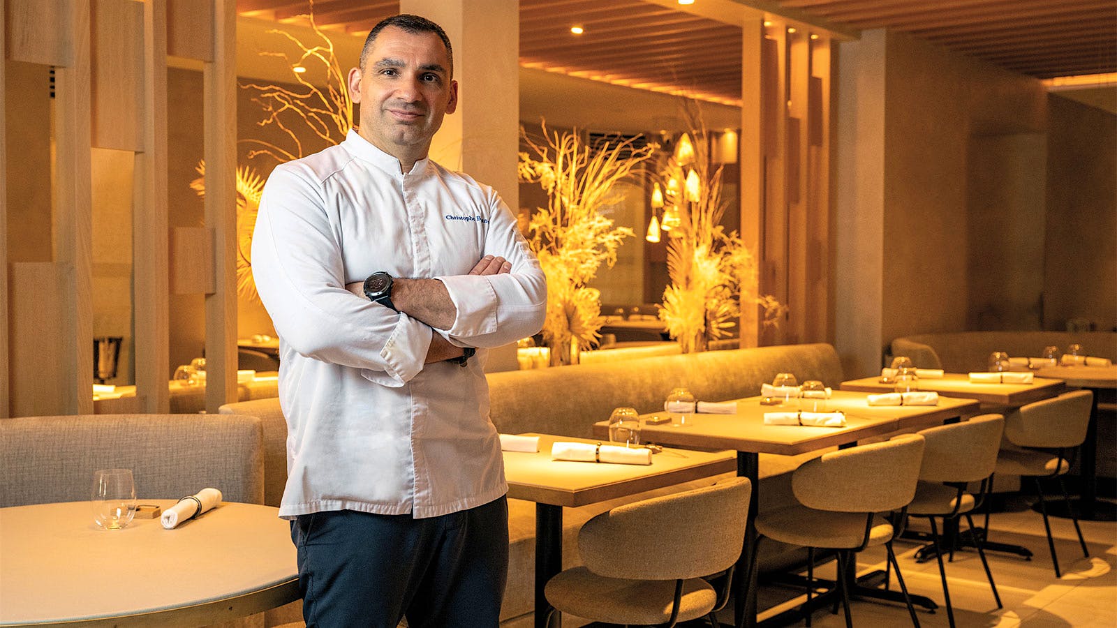 Chef Christophe Ballanca stands in the dining room of Essential by Christophe in New York City