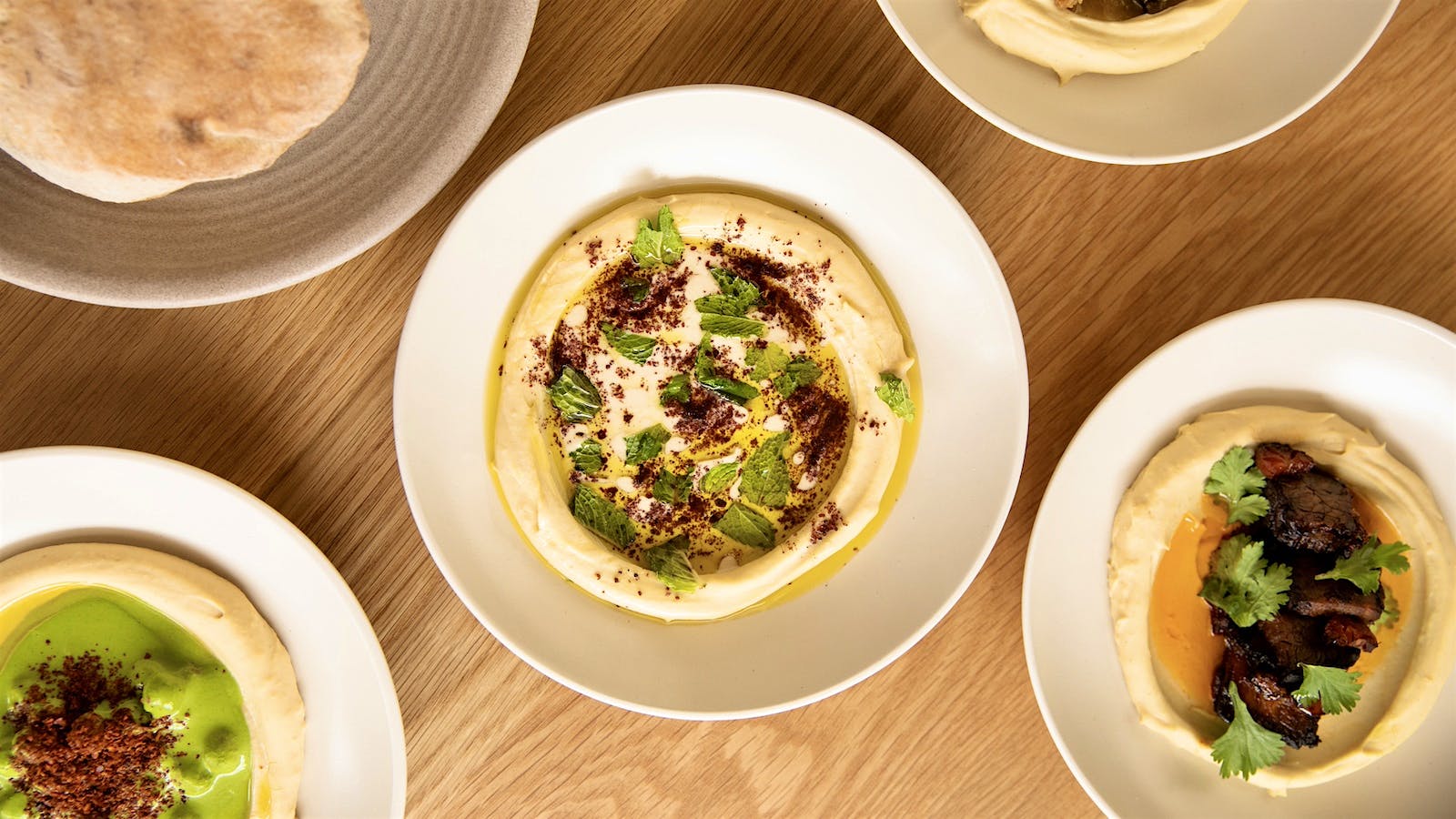 A plate of hummus from Galit Restaurant, topped with parsley and sumac