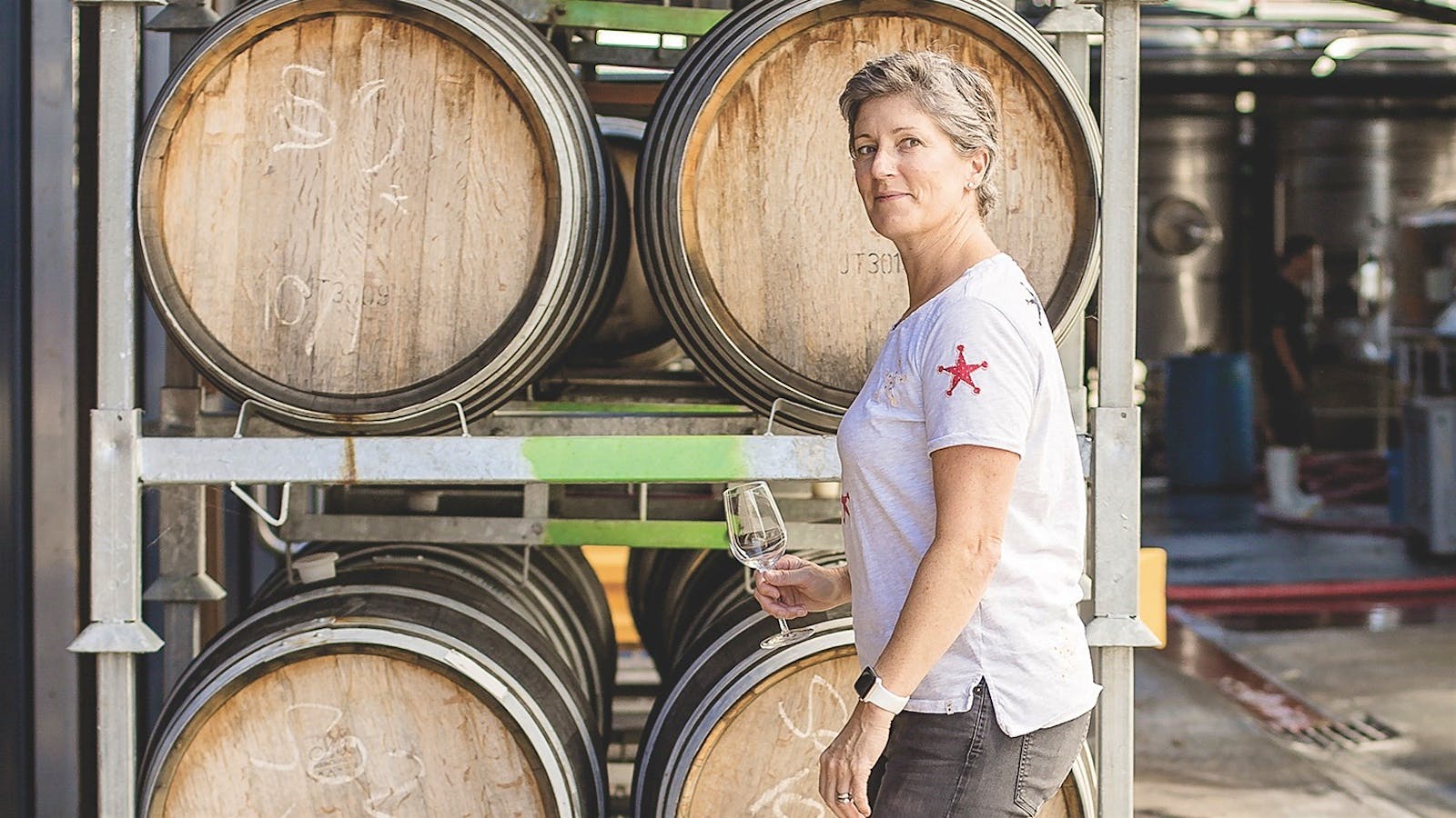 Jules Taylor walks through the barrel room of Jules Taylor Wines in Marlborough, New Zealand, with a glass of Sauvignon Blanc.