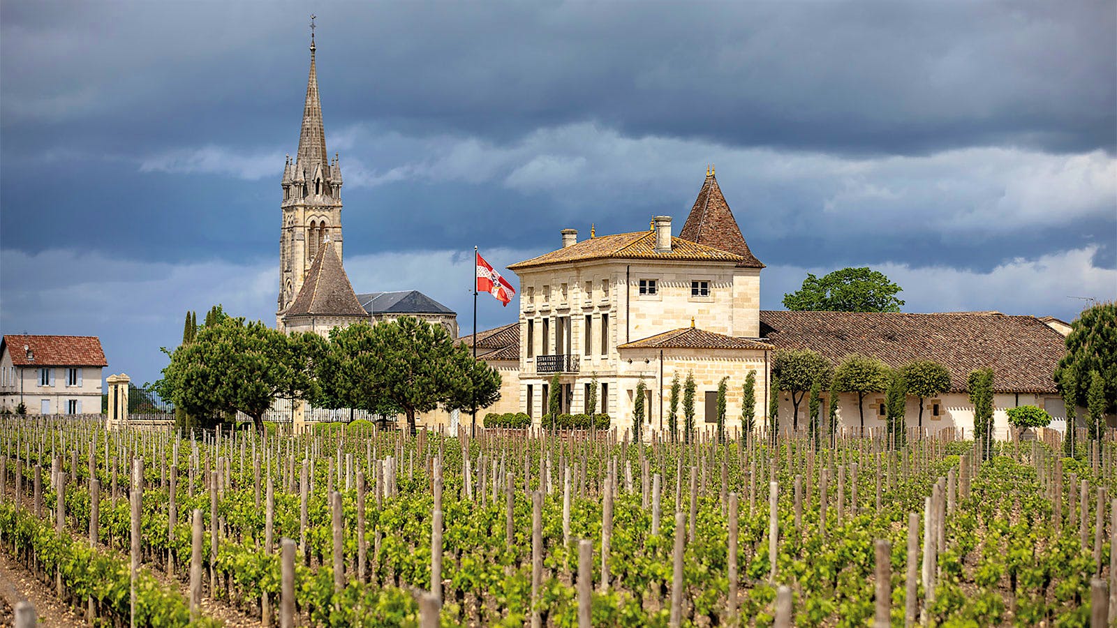 Château La Fleur-Pétrus in Pomerol, Bordeaux, with several buildings in the background.