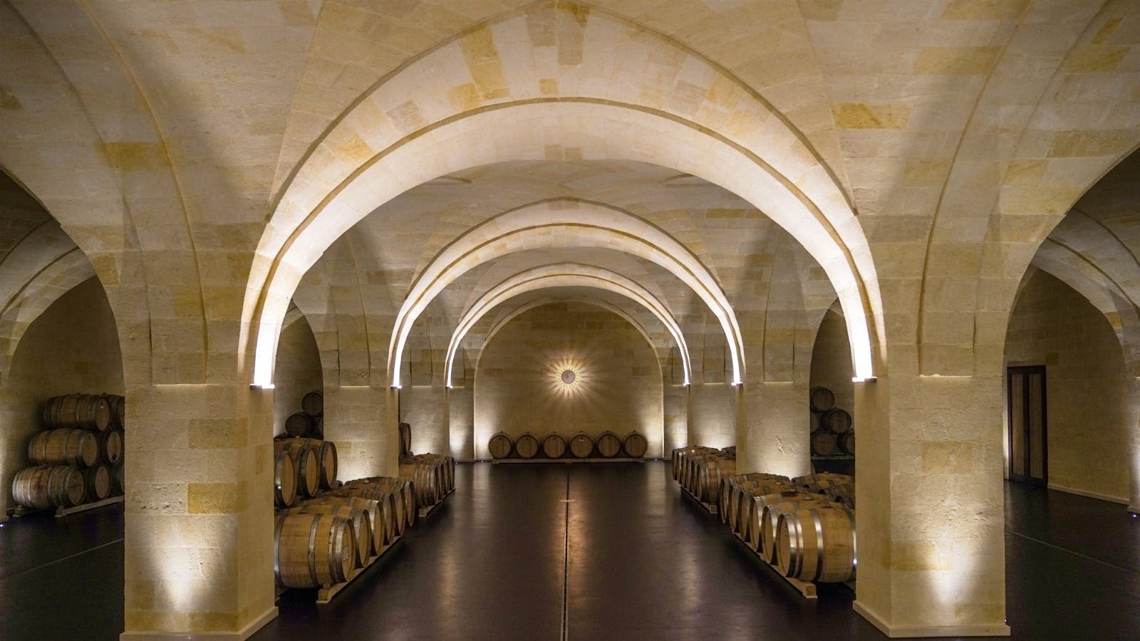 Gianfranco Fino's underground barrel room in Puglia, Italy, with marble arches, buttressed ceilings and a sculpture of the sun on the far wall