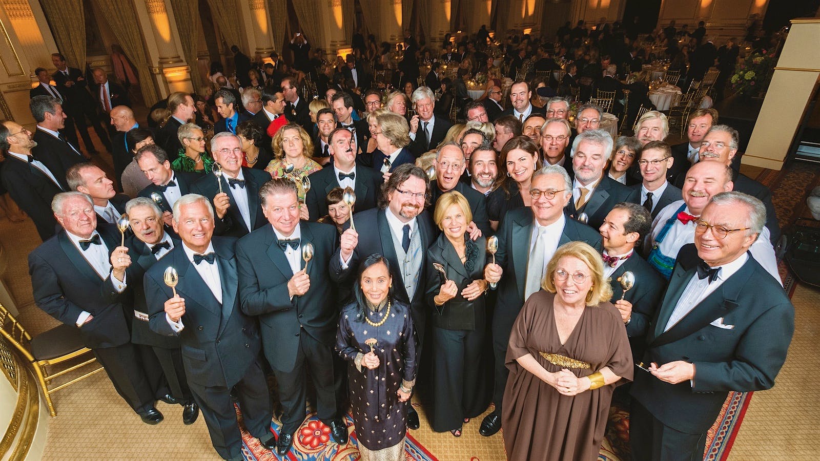 Award winners and attendees of the Food Arts 20th Anniversary Gala in 2008 hold silver spoons aloft.