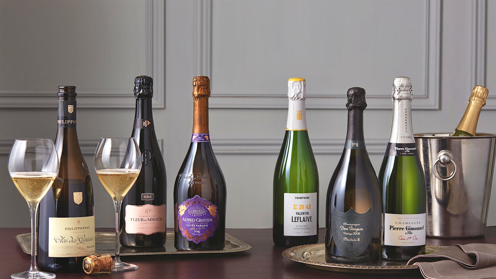 Champagne bottles are displayed alongside poured glasses on a table.